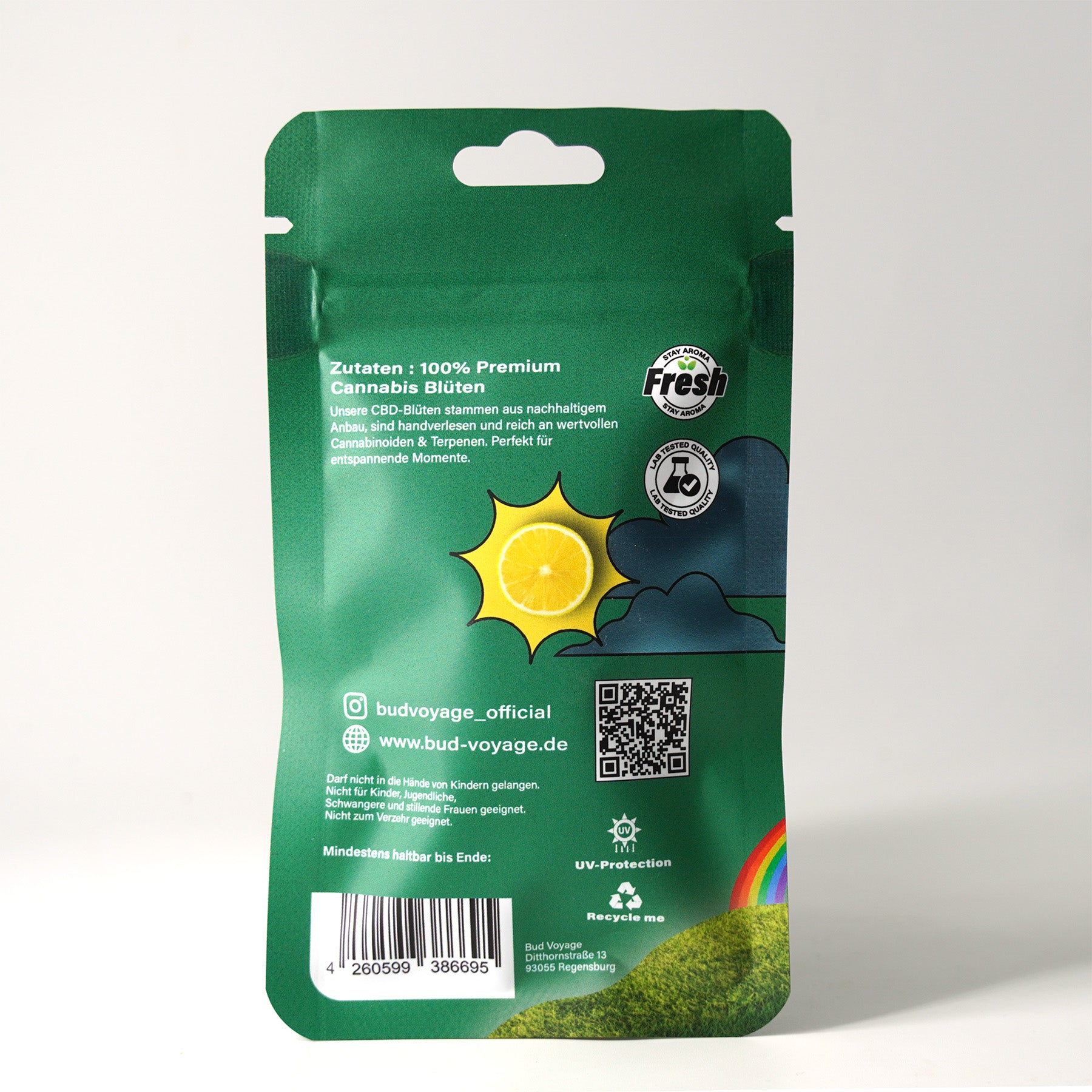 Bud Voyage Produktverpackung mit Illustration einer Zitronenscheibe in einer Sonne, grünen Hügeln und einem Regenbogen auf grünem Hintergrund,  zeigt  QR-Code und  UV-Schutz