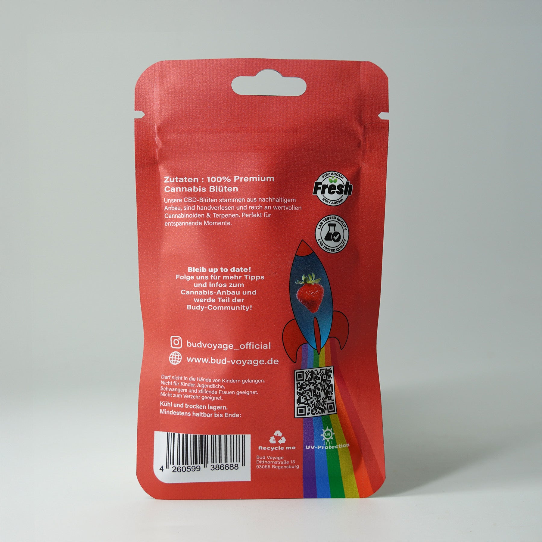 Bud Voyage Verpackung:  Premium Cannabis Blüten in einer roten Verpackung mit Raketenmotiv, Erdbeer und Regenbogenfarben, UV-Schutz und QR-Code.
